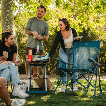 A group of people eating snacks at a park while they sit in Comfort Pro Rockers and BreezeRockers. 